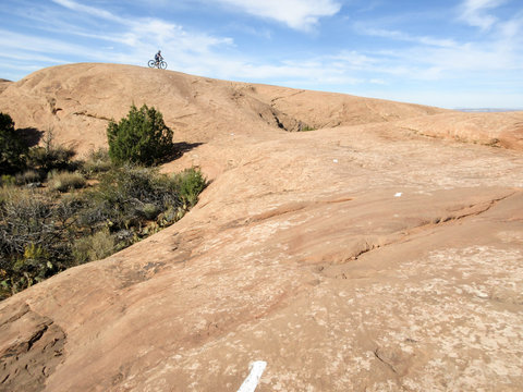 Mountain biker on top of a hill at Slickrock mountain biking trail in Moab, Utah