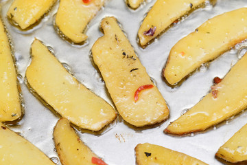 Slices of potato fried on a metal surface in hot oil food background wallpaper texture
