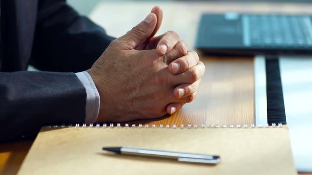 hands of a contemplating businessman sitting in office