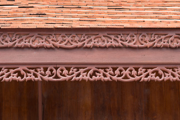 detail of traditional thai house roof style and eave board with wooden shingle and clay tiles