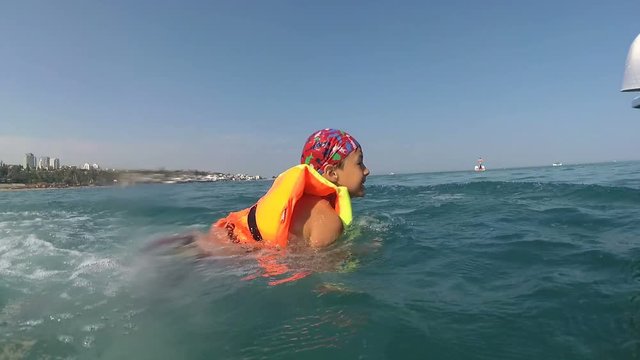 family vacation boy on pedal boat pulls off the hill into the sea, view from water