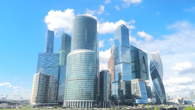 modern glass towers on the river bank in summer timelapse