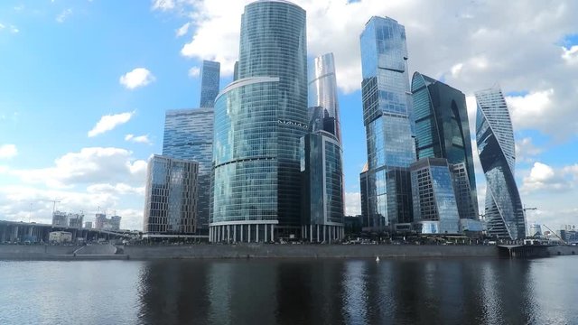 modern glass towers on river bank in summer timelapse