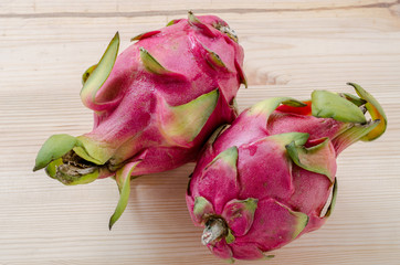 Fresh dragon fruits on wooden background.