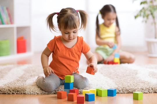 Children toddlers girls playing toys at home, kindergarten or nursery
