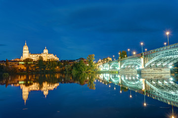 The Cathedral of Salamanca and the river Tormes with the Puente de Enrique Estevan at night