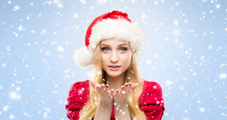 Portrait of young and beautiful girl in Christmas hat over winter background