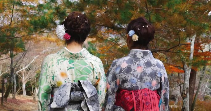 Young Japanese women walking through a park in Kyoto.