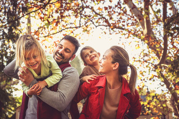 Smiling parents carrying daughters, have fun.