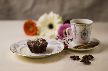 Chocolate fondant on a white plate with coffee and flowers