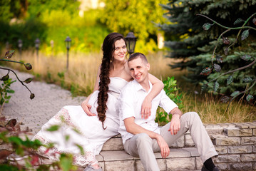 Happy pregnant family is walking in the park.