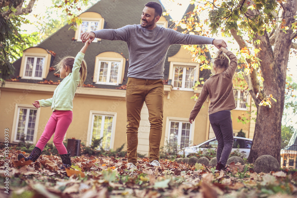 Wall mural happy father with daughters playing outside. on the move.