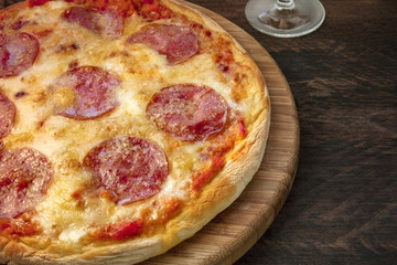 Pepperoni pizza on a rustic texture, closeup photo