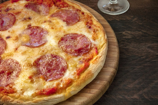 Pepperoni pizza on a rustic texture, closeup photo