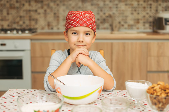 Portrait cute boy shef looking to camera while cooking