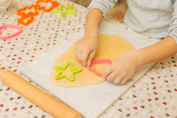 Hands of preschool boy making biscuits using cookie molds