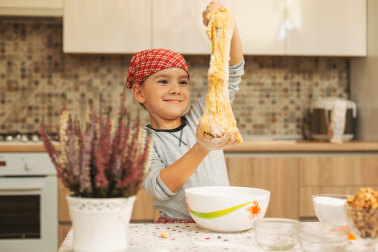 Cheerful boy have fun while making dough for cookies