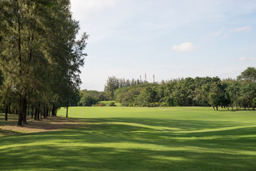 A lush green golf course under the blue sky.