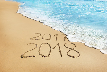 digits  2017 and  2018 on the sand
