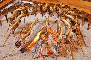 Fish Ayu with salt being charcoal broiled in Japan.                     