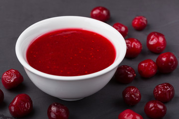 A bowl of red sweet sauce and ingredients on a plate
