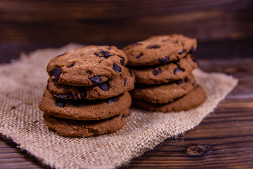Fototapeta na wymiar Chocolate chip cookies on sackcloth on a wooden table