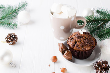 Christmas chocolate muffin on white wooden table.