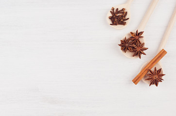 Christmas food - mulled wine background. Wood spoons with anise stars, cinnamon, clove on wood white board. Top view.