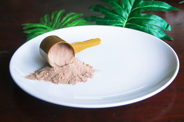 whey protein scoop on white plate on wooden table with copyspace , low carb, ,Healthy powder that will boost energy and build muscle.
