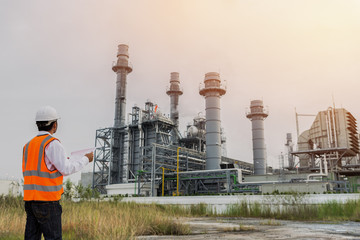 Engineer in uniform and helmet on of background the construction site power plant