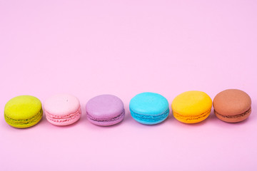 Small French macaroons on pastel background