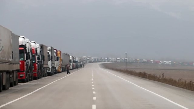 A Lot Of Trucks Waiting In Line In Front Of The Border