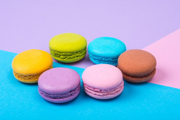 Fototapeta na wymiar Small French macaroons on pastel background