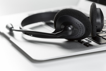 call center support concept. headset on keyboard computer laptop