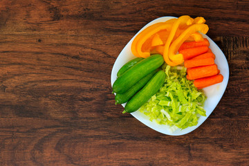 Delicious carrots, cucumbers, cabbage and peppers on a white plate