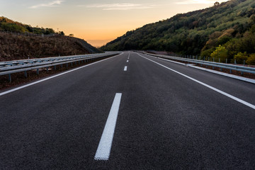 Empty Highway with markings at sunset