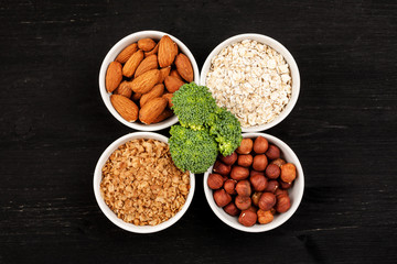 Nuts and cereals in a white ceramic dishes with broccoli