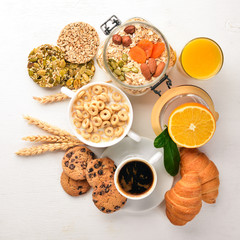 A healthy breakfast. Orange juice, kiwi, croissants, cookies, coffee, on a wooden surface. Top view. Free space for text.