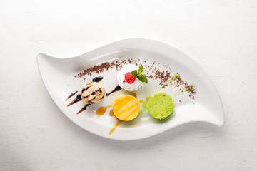 Panakota with taste of pistachio, orange, chocolate. On a wooden background. Free space for your text. Top view.