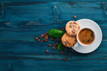 Coffee and oatmeal chocolate cookies on a wooden background. Coffee beans. Top view. Free space for...