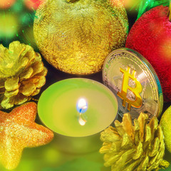 Bitcoin among Christmas decorations and a candle.