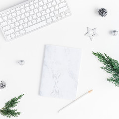 Christmas home office desk with computer, notebook, pine branches, christmas silver decorations. Flat lay, top view, copy space, square