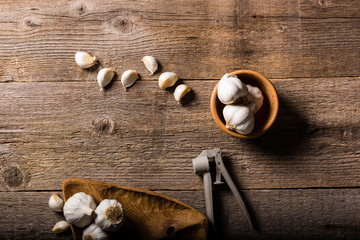 Garlic, Garlic cloves and Garlic bulb in vintage handmade wooden bowl on old table. Top view.