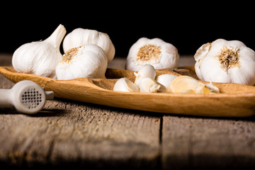 Garlic, Garlic cloves and Garlic bulb in vintage handmade wooden bowl. Front view.