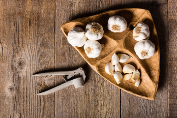 Garlic, Garlic cloves and Garlic bulb in vintage handmade wooden bowl. Top view.