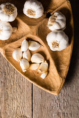 Garlic, Garlic cloves and Garlic bulb in vintage handmade wooden bowl. Top view.