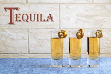 three portions of the Golden tequila with slices of marinated hot green jalapeno pepper