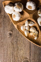 Garlic, Garlic cloves and Garlic bulb in vintage handmade wooden bowl. Top view.