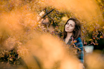 Outdoor lifestyle photo of young brunett girl in autumn park. Brown hair and eyes. Warm autumn. Copy space
