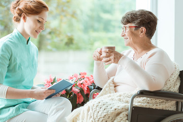 Assistant reads book for elderly